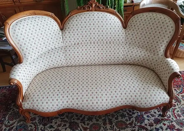 Ein wunderschön restauriertes antikes Sofa mit Blumenstoff.
